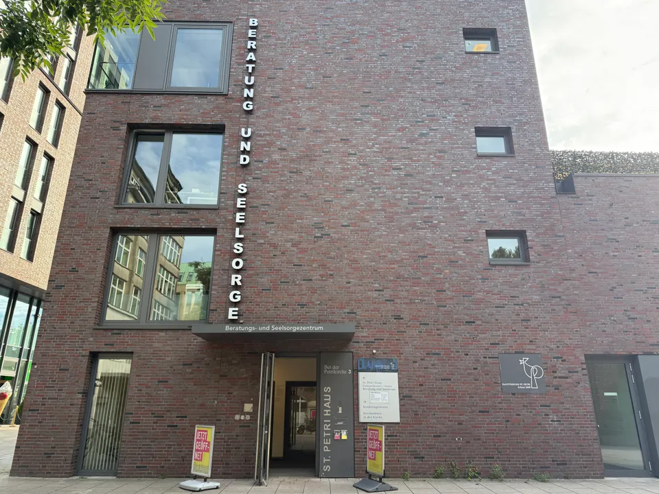 Rote Klinkerfassade des St. Petri Hauses mit senkrechtem Schriftzug „Beratung und Seelsorge“ und offenem Eingang