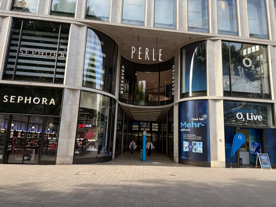 Eingang der Einkaufspassage Perle in Hamburgs Spitalerstraße, flankiert von Sephora- und O2-Geschäften mit heller Steinfassade
