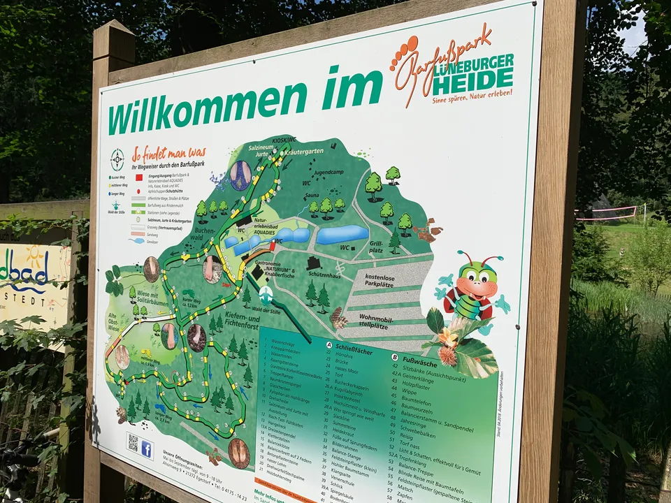 Übersichtstafel „Willkommen im Barfußpark Lüneburger Heide“ mit farbigem Lageplan der Wege, Stationen und Parkplätze