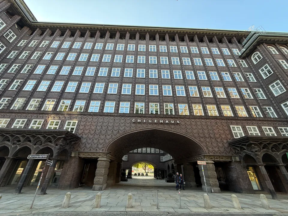 Klinkerfassade des Chilehauses mit großer Bogendurchfahrt, Schriftzug Chilehaus und Straßenschild Burchardplatz