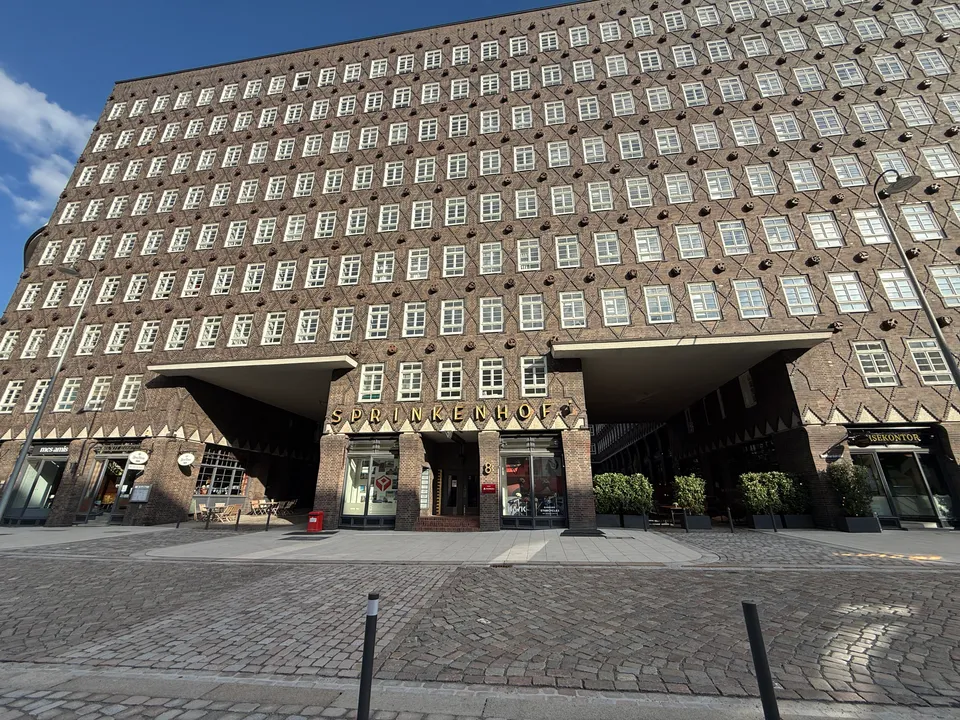 Klinkerfassade des Sprinkenhofs mit Rautenmuster, zwei Durchfahrten und goldenem Schriftzug über dem Eingang