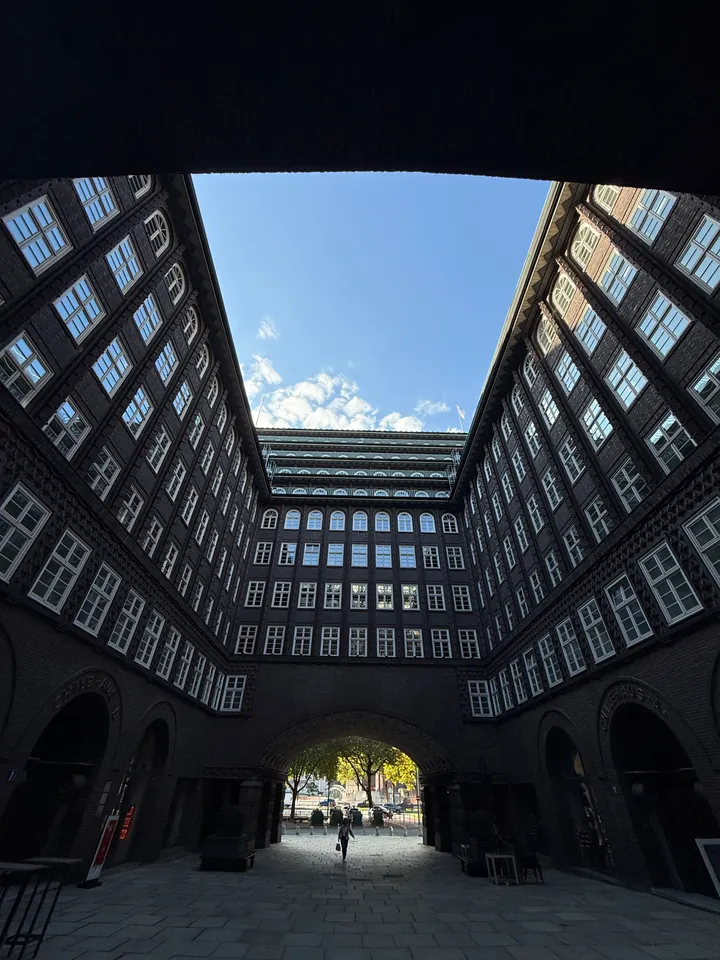 Innenhof des Chilehauses mit hohen Klinkerfassaden und Sprossenfenstern, gesehen aus einer dunklen Durchfahrt