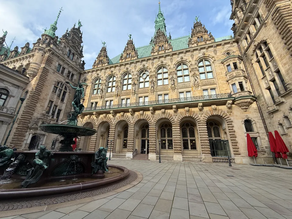 Hygieia-Brunnen mit Bronzefiguren im Innenhof des Hamburger Rathauses vor verzierter Arkadenfassade