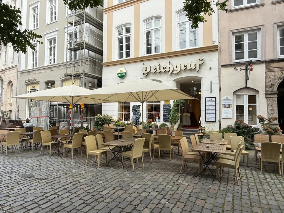 Restaurant Deichgraf in der Hamburger Deichstraße mit leerer Außenterrasse, Sonnenschirmen und Tischen auf Kopfsteinpflaster
