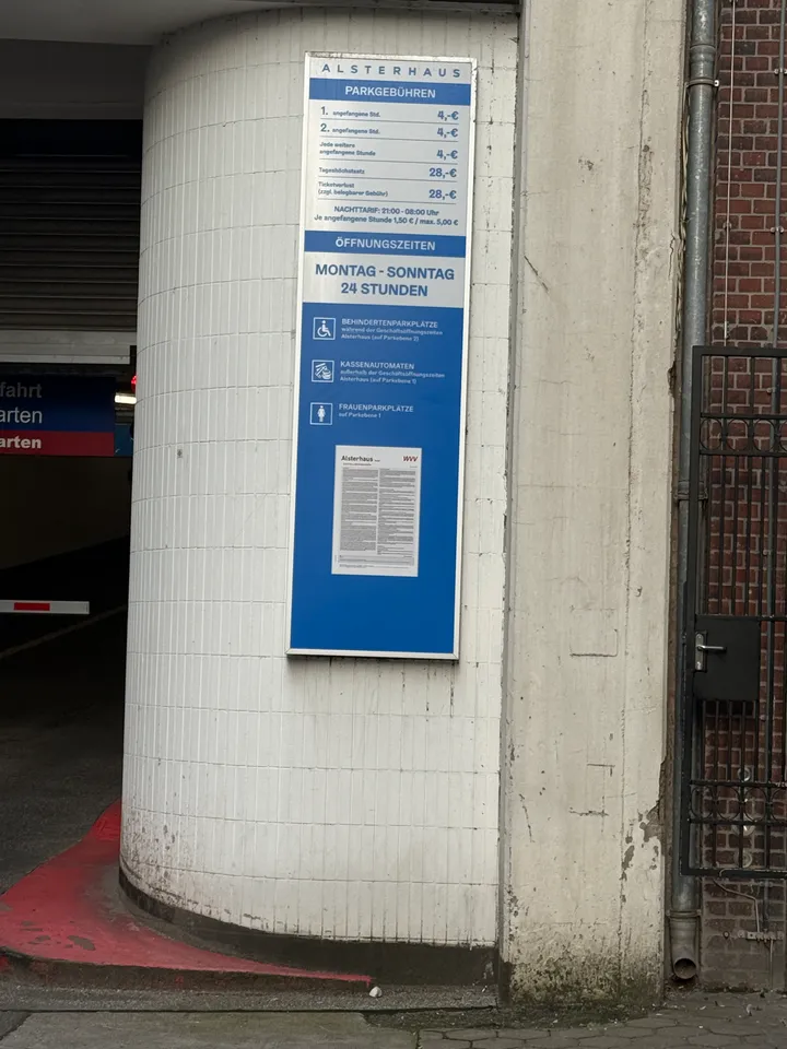 Blau-weiße Tafel mit Parkgebühren und Öffnungszeiten des Parkhauses Alsterhaus an einer weiß gefliesten Säule