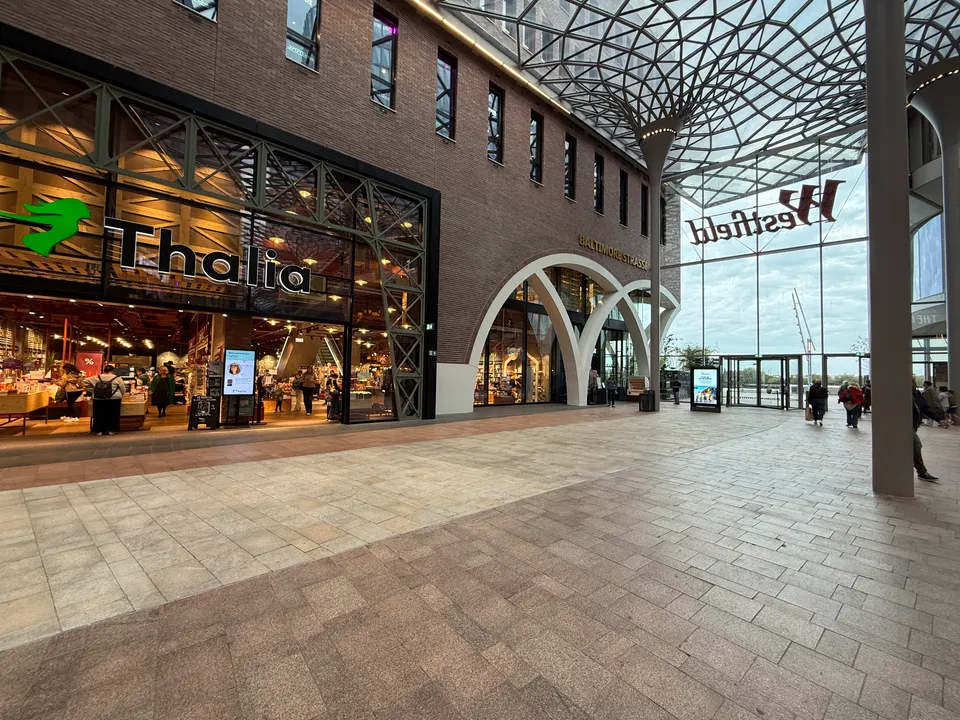 Überdachte Einkaufspassage mit Thalia-Buchhandlung links, Glasdach mit baumartigen Stützen und Glasfront mit Westfield-Schriftzug